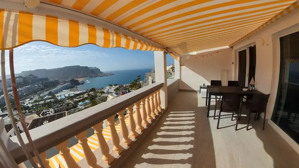 Apartment terrace with striped awning overlooking the sea and Playa del Cura